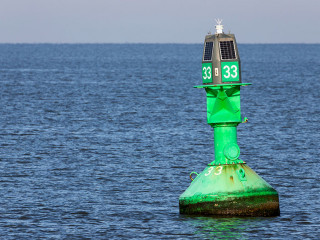 green lateral buoy at the edge of a fairway