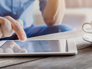 Businessman using digital tablet computer on wooden table, coffe