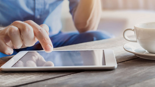 Businessman using digital tablet computer on wooden table, coffe