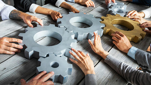 Business people joining gears