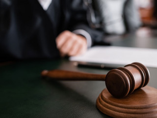 selective focus of wooden gavel near cropped judge on blurred background