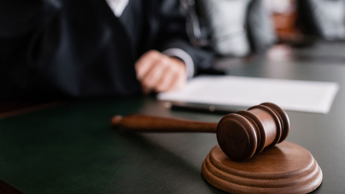 selective focus of wooden gavel near cropped judge on blurred background