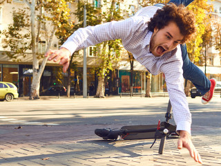 Accident with an electric scooter. A man fell from a scooter on a city street.