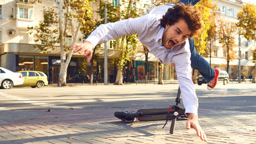 Accident with an electric scooter. A man fell from a scooter on a city street.