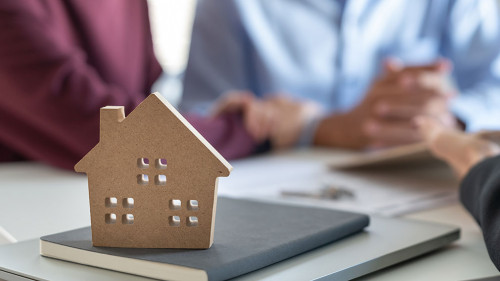 Young family couple talking with property real estate agent abou