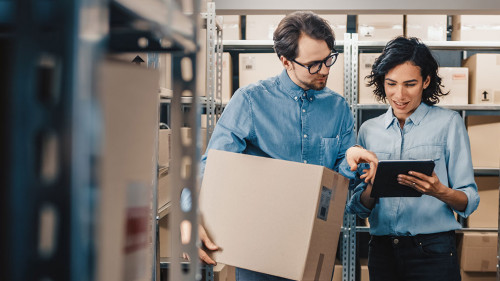 Female Inventory Manager Shows Digital Tablet Information to a W