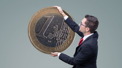 Geldanlage – Mann im Anzug stapelt Geldmünzen