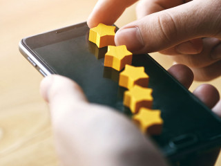 hand gives five stars rating as product feedback with smart phone