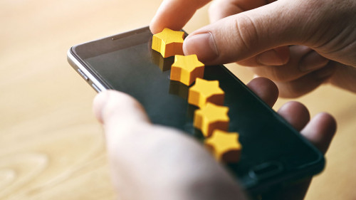 hand gives five stars rating as product feedback with smart phone