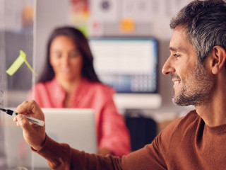 Brainstorming Creative Business Team Putting Ideas Onto Glass Screen In Office