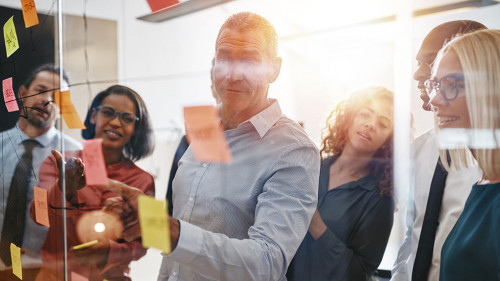Manager and his business team brainstorming on a glass wall