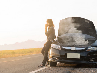 Broken car. Lady standing on the road