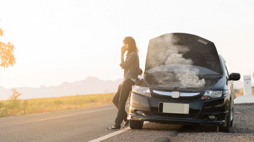 Broken car. Lady standing on the road