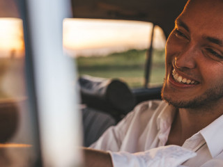Closeup portrait of handsome happy male driver smiling while sit
