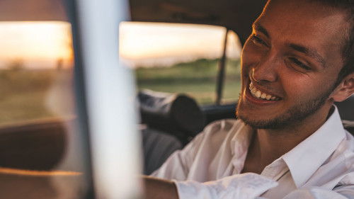 Closeup portrait of handsome happy male driver smiling while sit