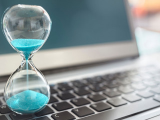 Hourglass on laptop computer concept for time management