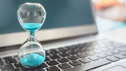 Hourglass on laptop computer concept for time management