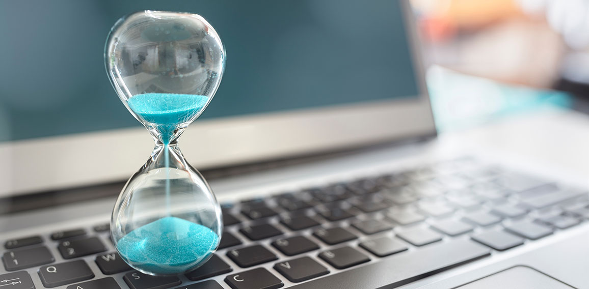 Hourglass on laptop computer concept for time management