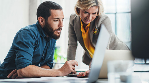Coworkers team at work. Group of young business people in trendy casual wear working together in creative office