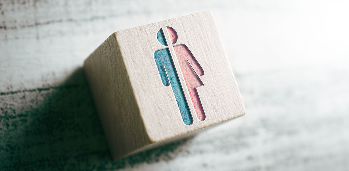Gender Icons For Male And Female Cut In Half On A Wooden Block On A Table
