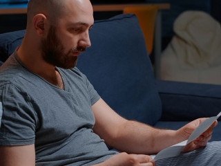 Angry stressed depressed man reading bad news in mail letter