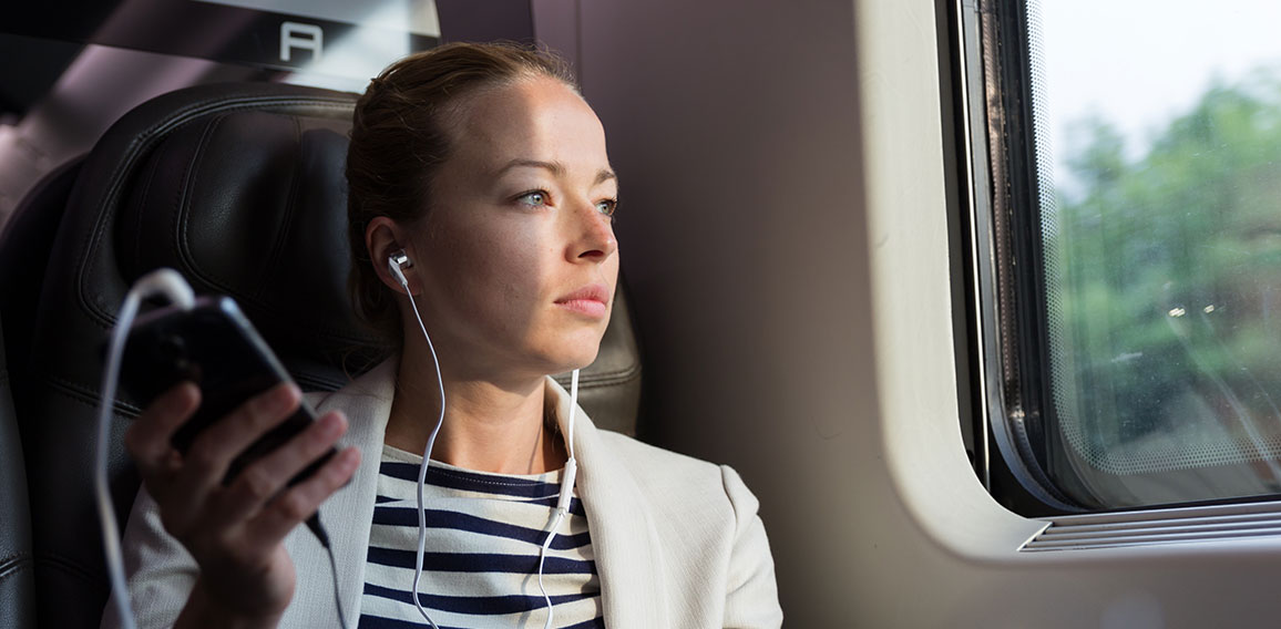 Businesswoman communicating on mobile phone while traveling by train.