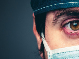 Coronavirus, medico stanco che piange. Primo piano.