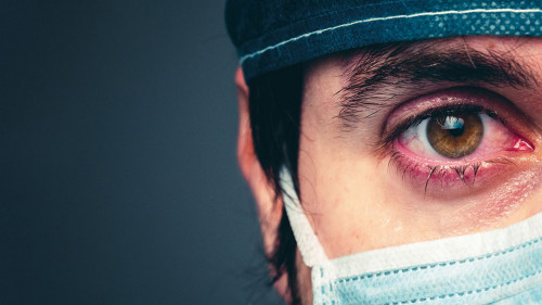 Coronavirus, medico stanco che piange. Primo piano.