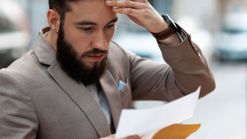 Big debt alert. A shocked man reads a court letter. Death of a l
