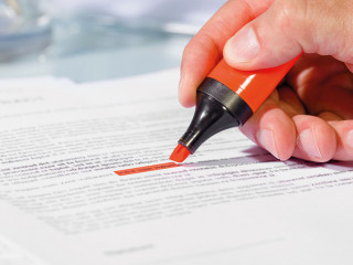 Close-up of hand with highlighter over document