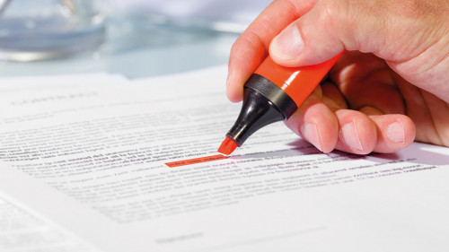 Close-up of hand with highlighter over document