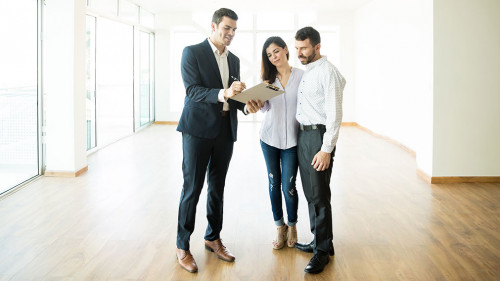 Realtor Explaining Agreement To Couple In New Apartment