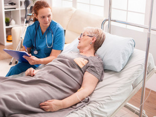 Senior woman lying in nursing home bed