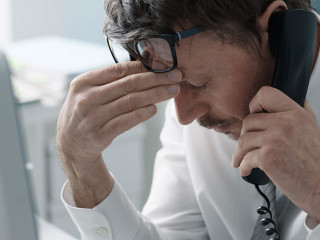 Business executive receiving bad news on the phone