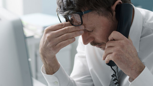 Business executive receiving bad news on the phone