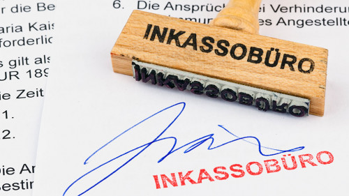 Holzstempel auf Dokument: Inkassobüro