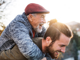 Senior father and his son walking in nature, having fun.