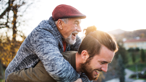 Senior father and his son walking in nature, having fun.