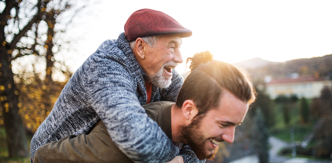 Senior father and his son walking in nature, having fun.