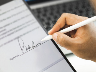 Close up businessman hand electronic Signature on Tablet by Styl