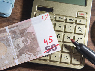 Euro money with a marker, calculator on the wooden background. I