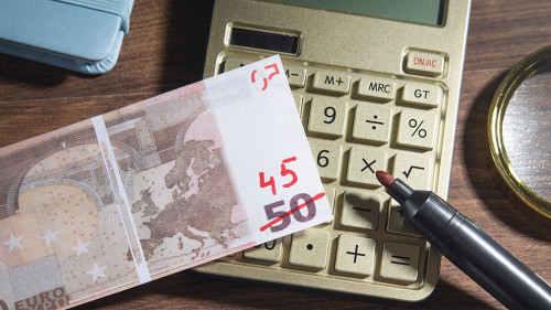 Euro money with a marker, calculator on the wooden background. I