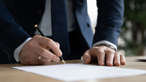 Close up young businessman ready signing profitable offer agreement.