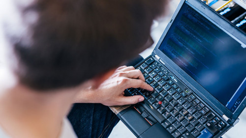 IT specialist working on computer in bitcoin and crypto currency mining farm.