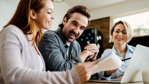 Bellow view of happy couple having a meeting with insurance agent.