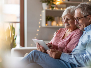 Mature couple using a laptop while relaxing at home