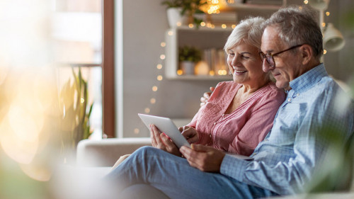 Mature couple using a laptop while relaxing at home