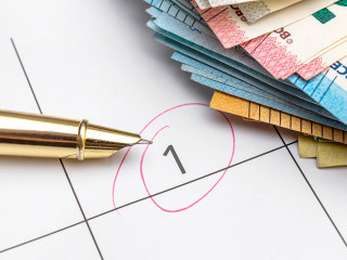 Payment day highlighted on calendar with heap of euro bills. Clo