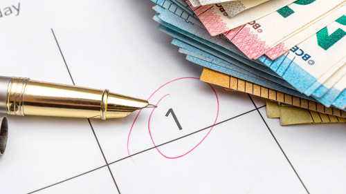 Payment day highlighted on calendar with heap of euro bills. Clo