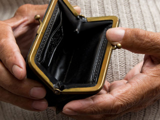 An elderly man holds an empty purse. The concept of poverty in r